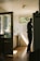 A happy customer standing next to a new refrigerator in a bright kitchen.
