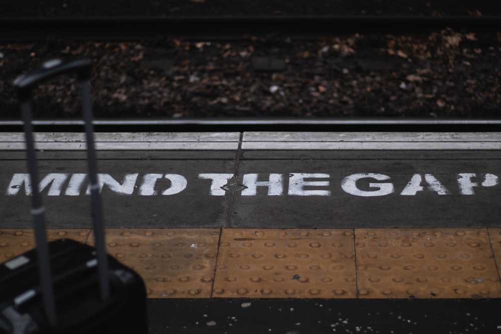 a piece of luggage sitting on the side of a train track