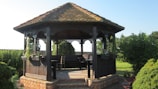 A sturdy wooden gazebo built in a sunny backyard.