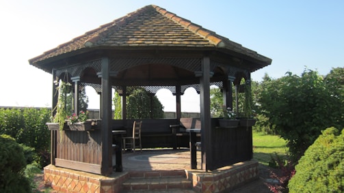 A sturdy wooden gazebo built in a sunny backyard.