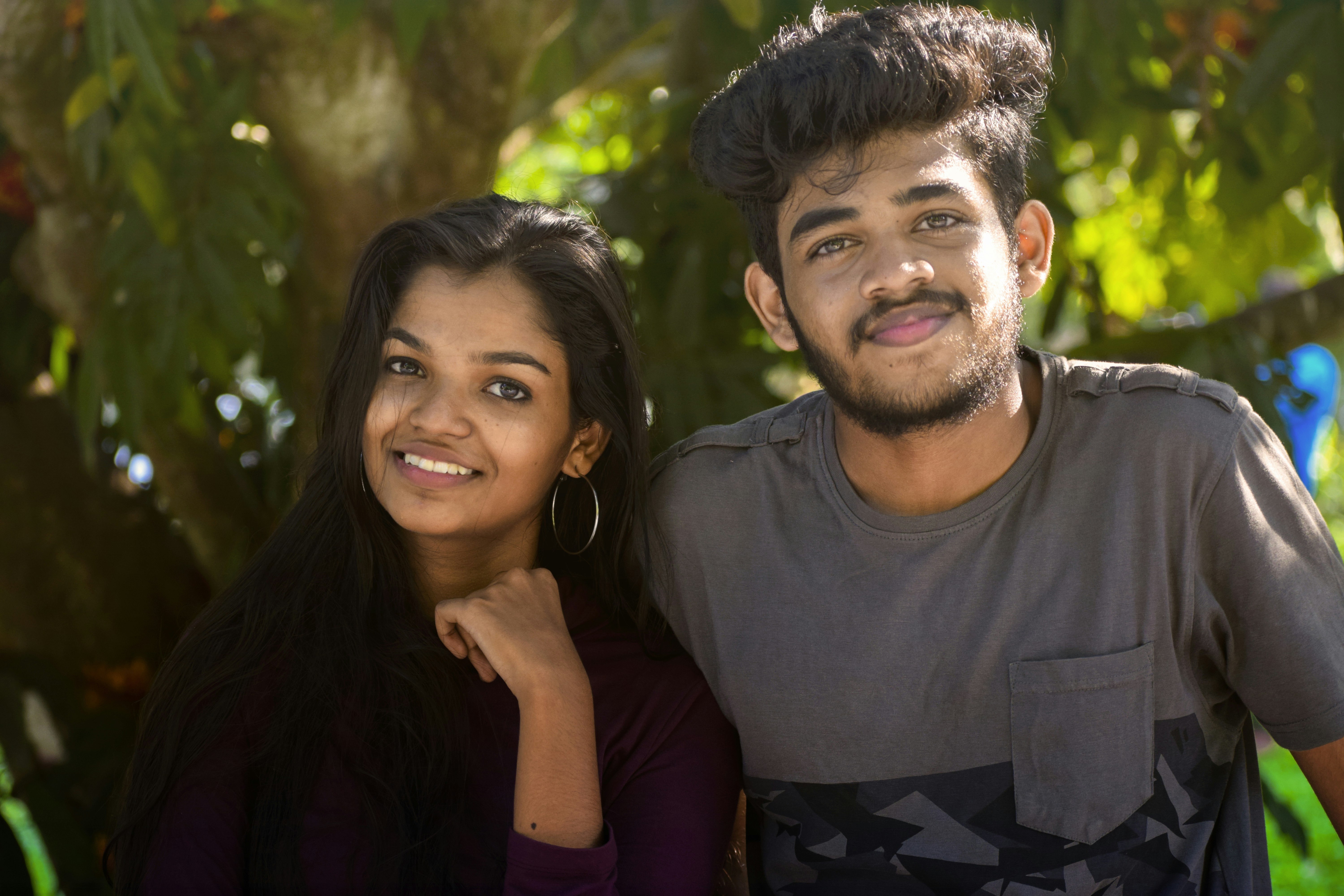 man in grey crew-neck shirt beside woman near tree