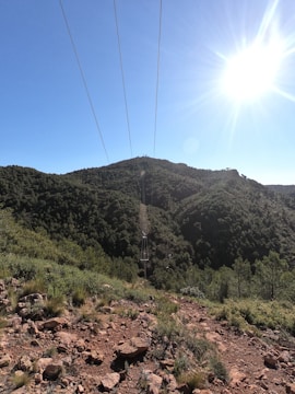 Power transmission lines stretching across a green landscape.