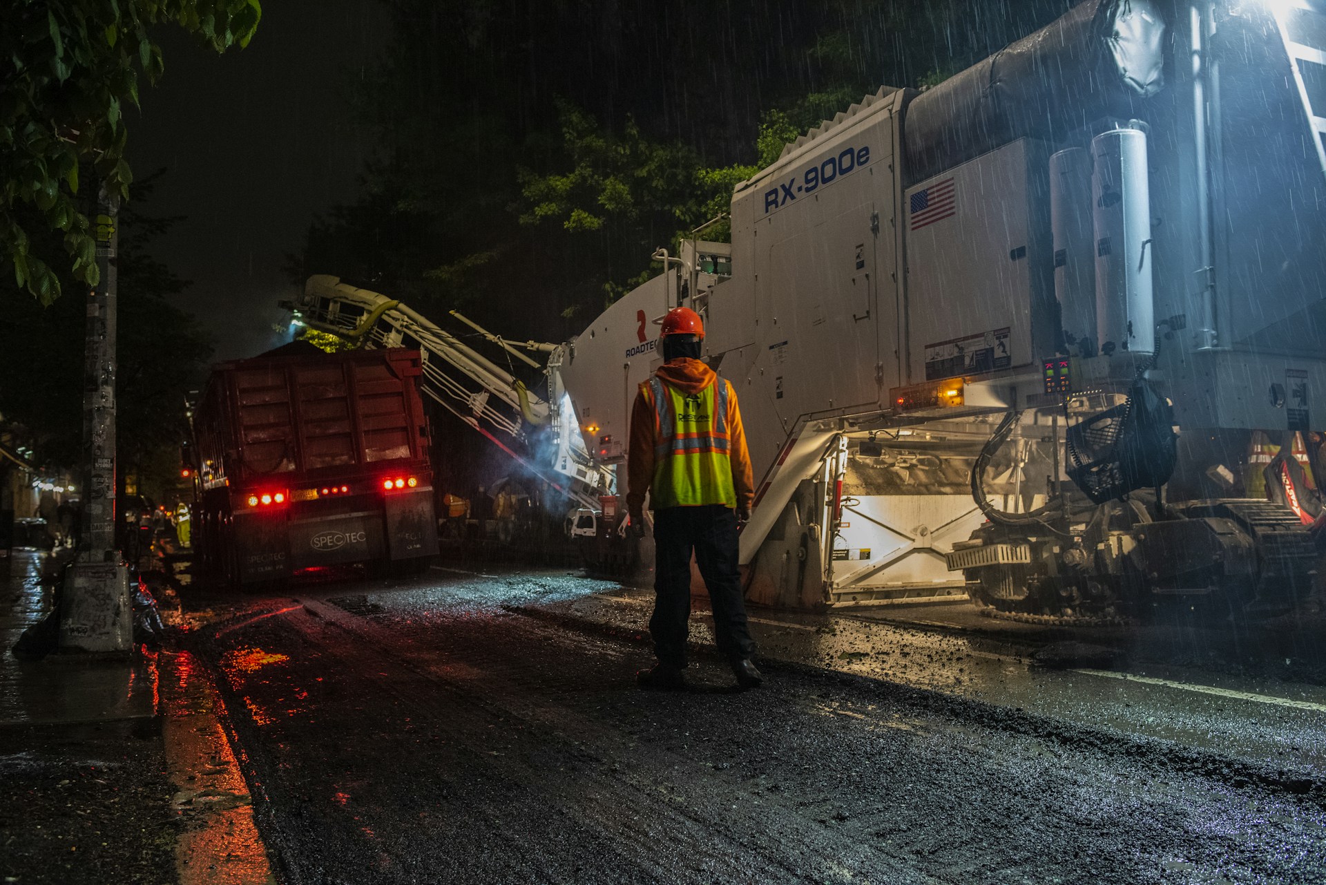 man wearing orange hard hat standing near truck