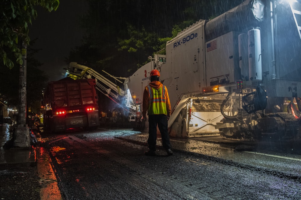 man wearing orange hard hat standing near truck