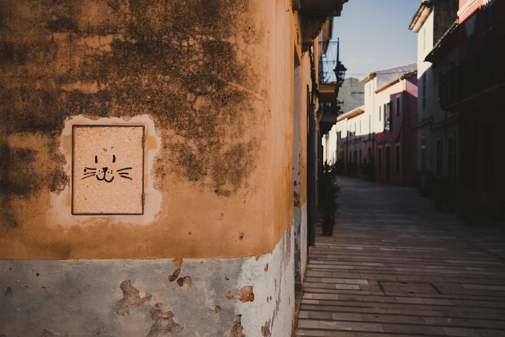 a sign on the side of a building with a cat drawn on it