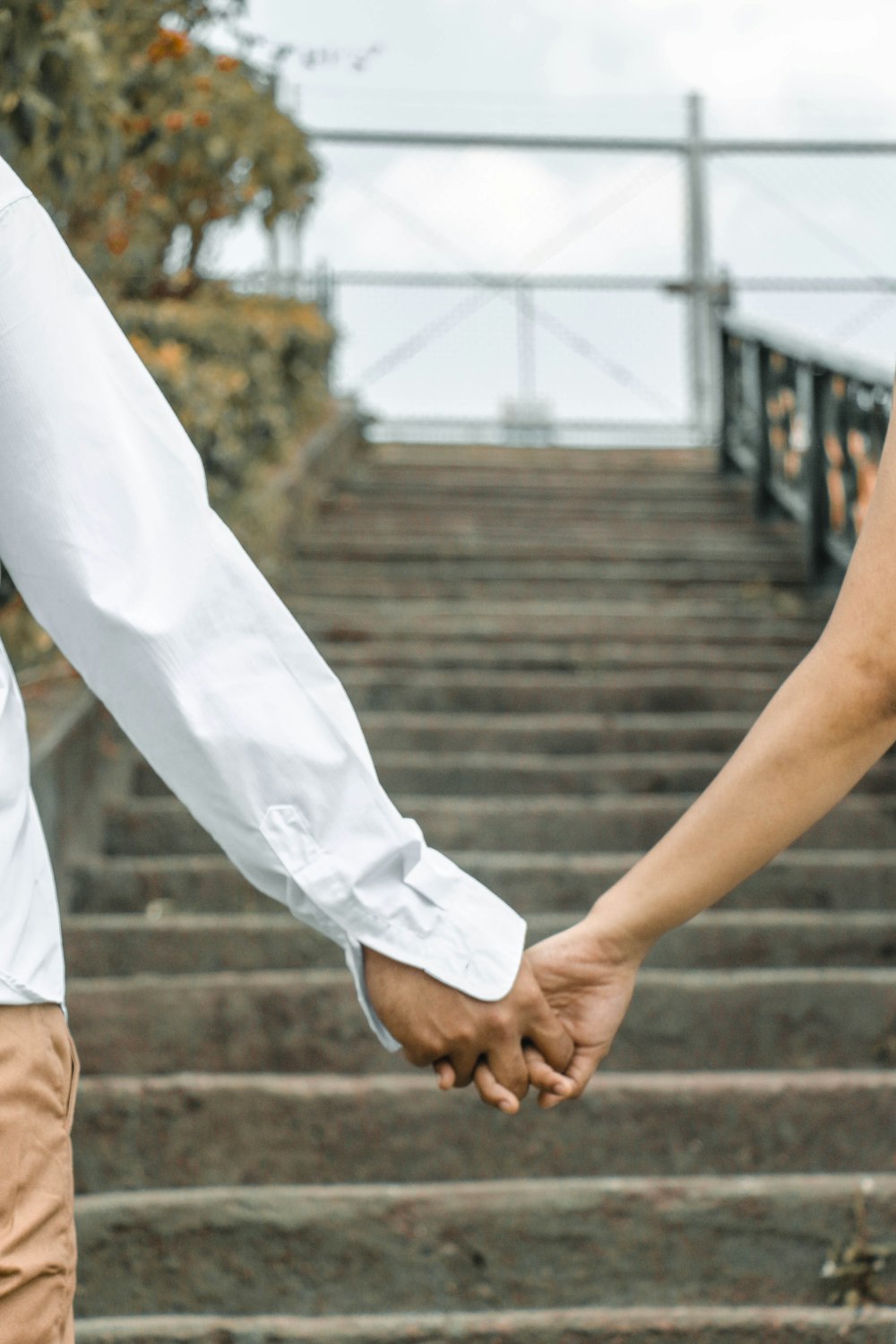 couple holding hand by the stairs outdoors