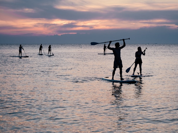 silhouette of Amberly Martin riding on paddle boards