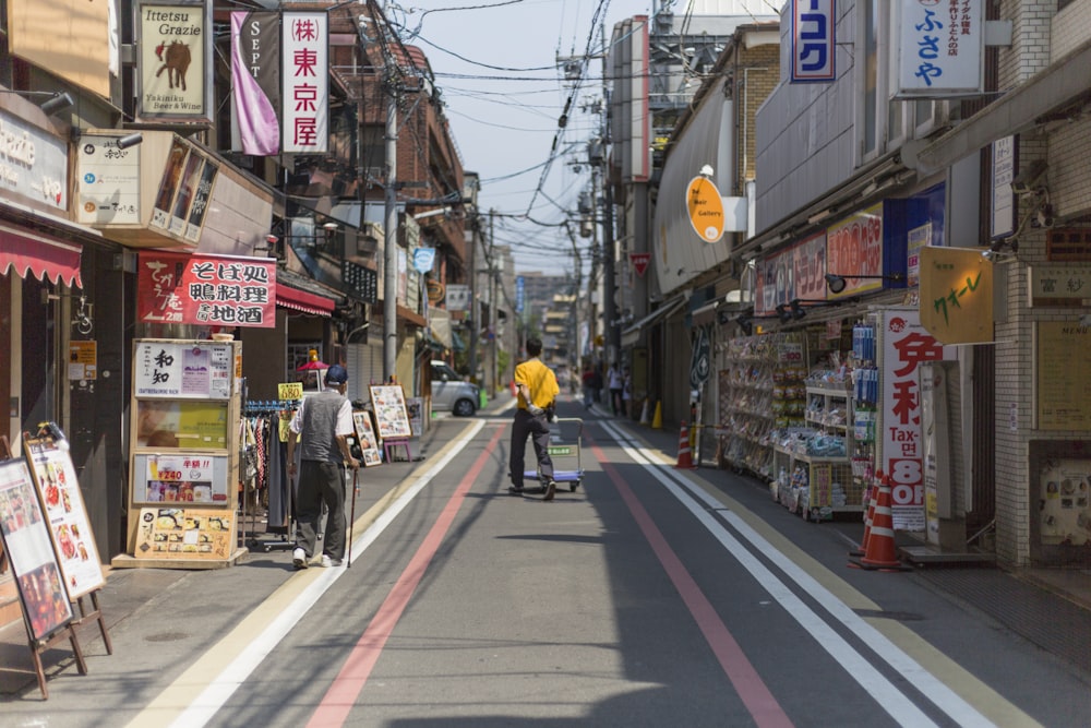 two men walking in the street near buildings