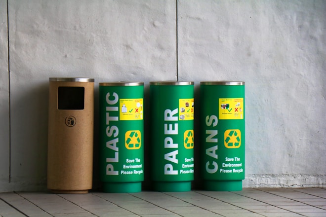 three green and one brown trash bins