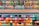 A variety of colorful markers arranged neatly on shelves. The markers are sorted by hues and tones, ranging from bright pinks, oranges, and reds to cool blues, greens, and purples. Each row displays a different gradient of shades.