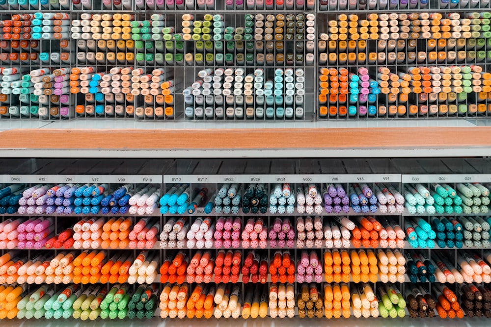 pila di pennarelli a penna di colori assortiti su scaffale acrilico