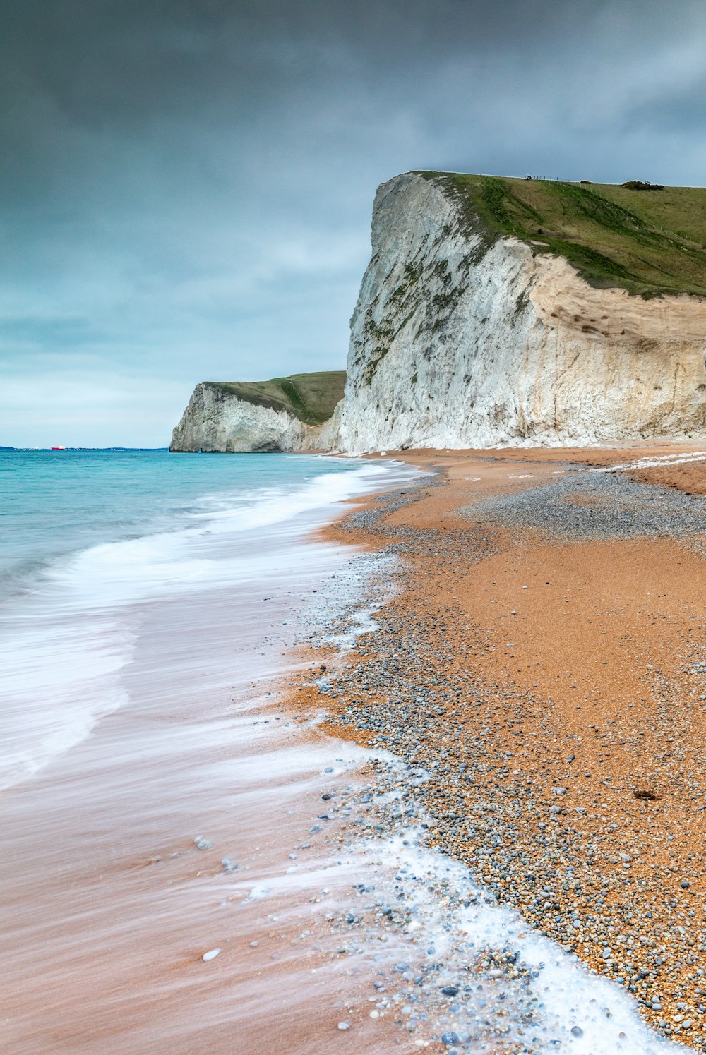 seashore under gray clouds at daytime