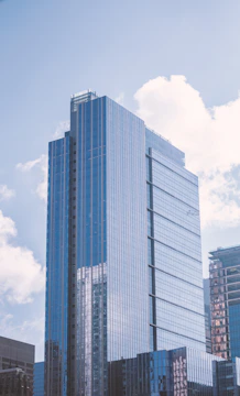 A modern skyscraper reflecting the sky in a bustling city