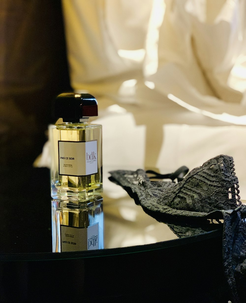 perfume bottle and grey brass on table