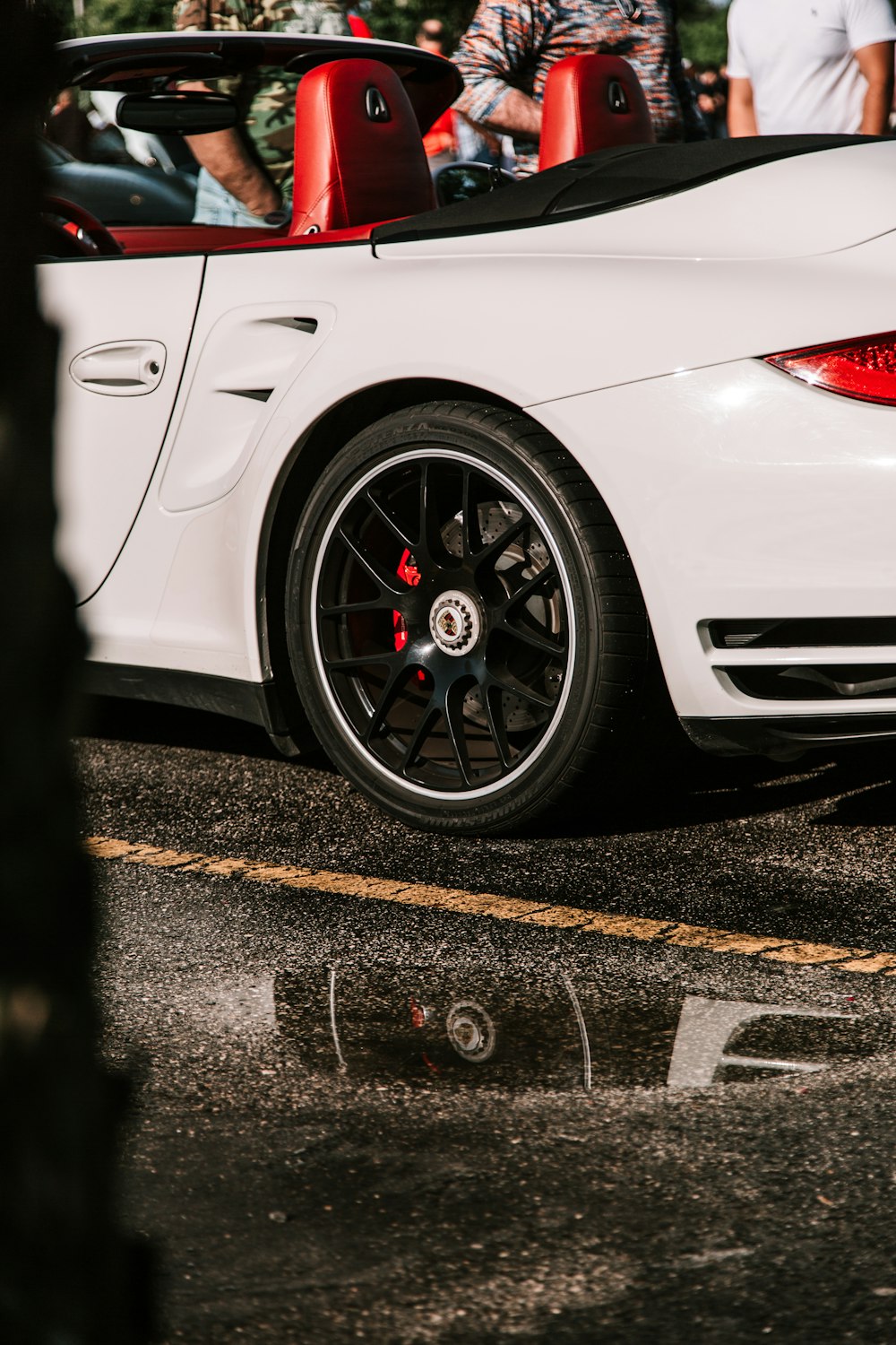 people standing beside luxury coupe