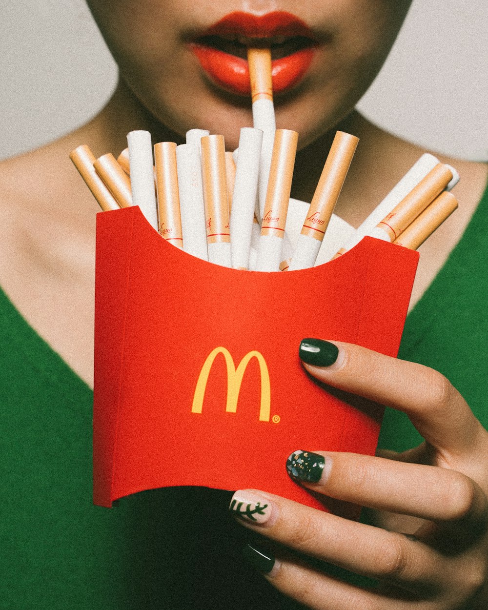 femme tenant un paquet de frites McDonald’s rempli de cigarettes