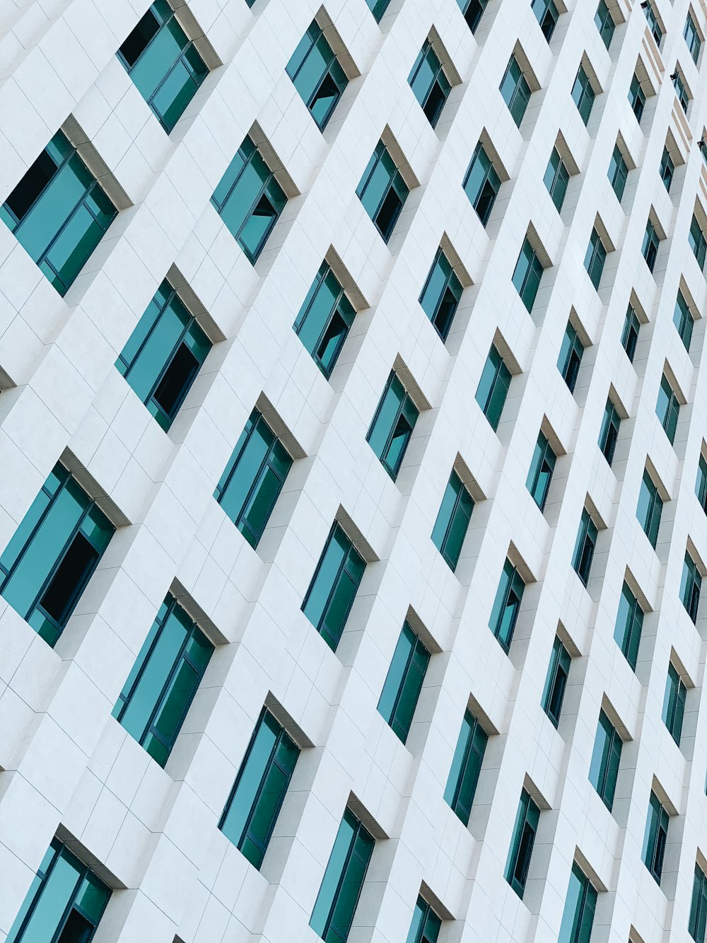 white tiled high-rise building with green tinted glass windows