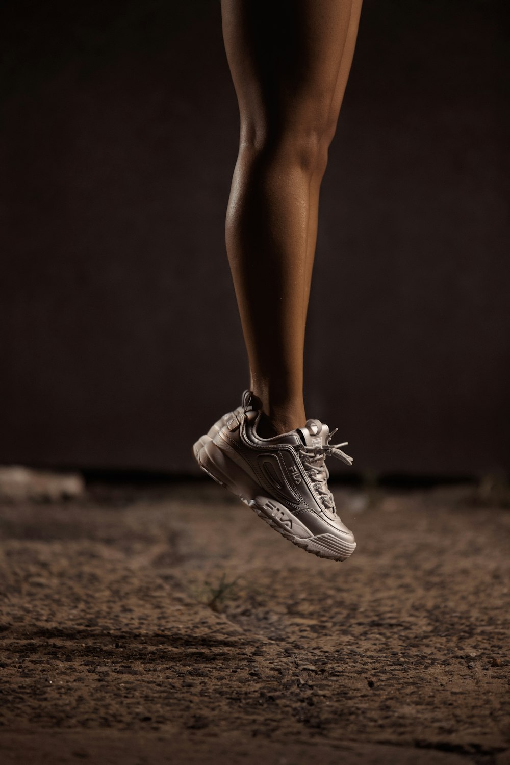 Fotografia a fuoco selettiva di una persona in scarpe da corsa che salta