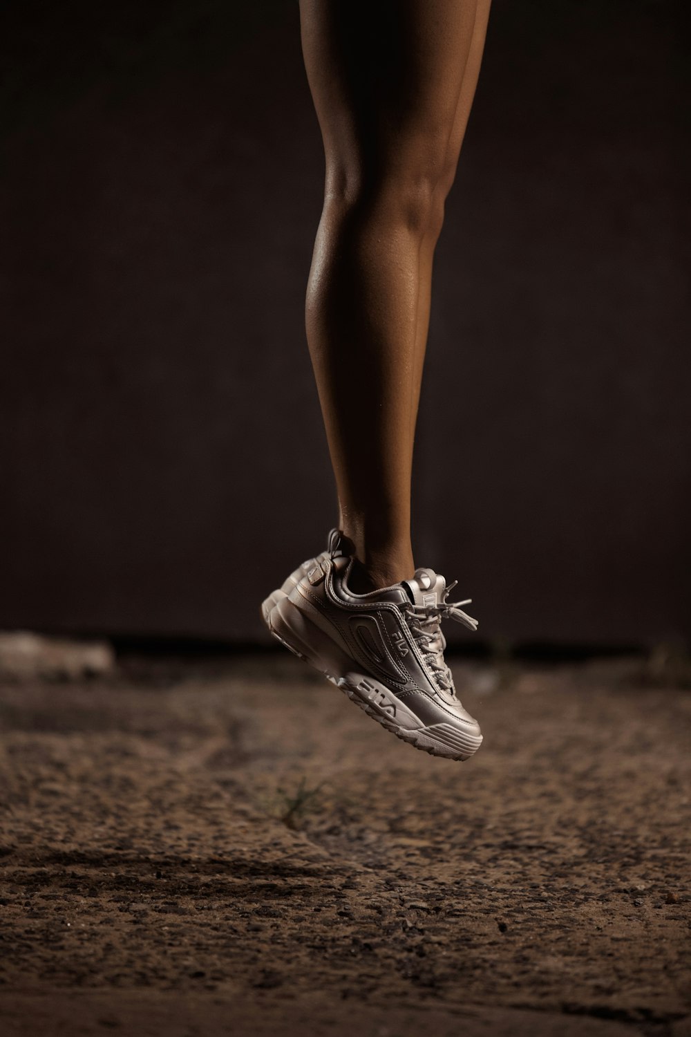 selective focus photography of person in running shoes jumping