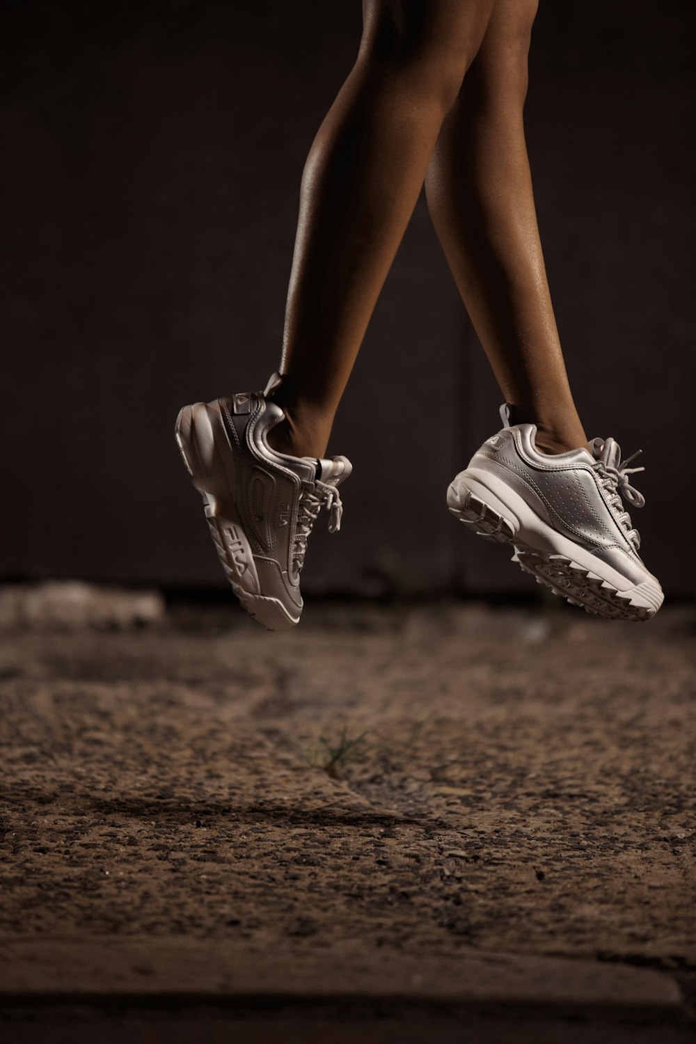 woman jumps using white sneakers