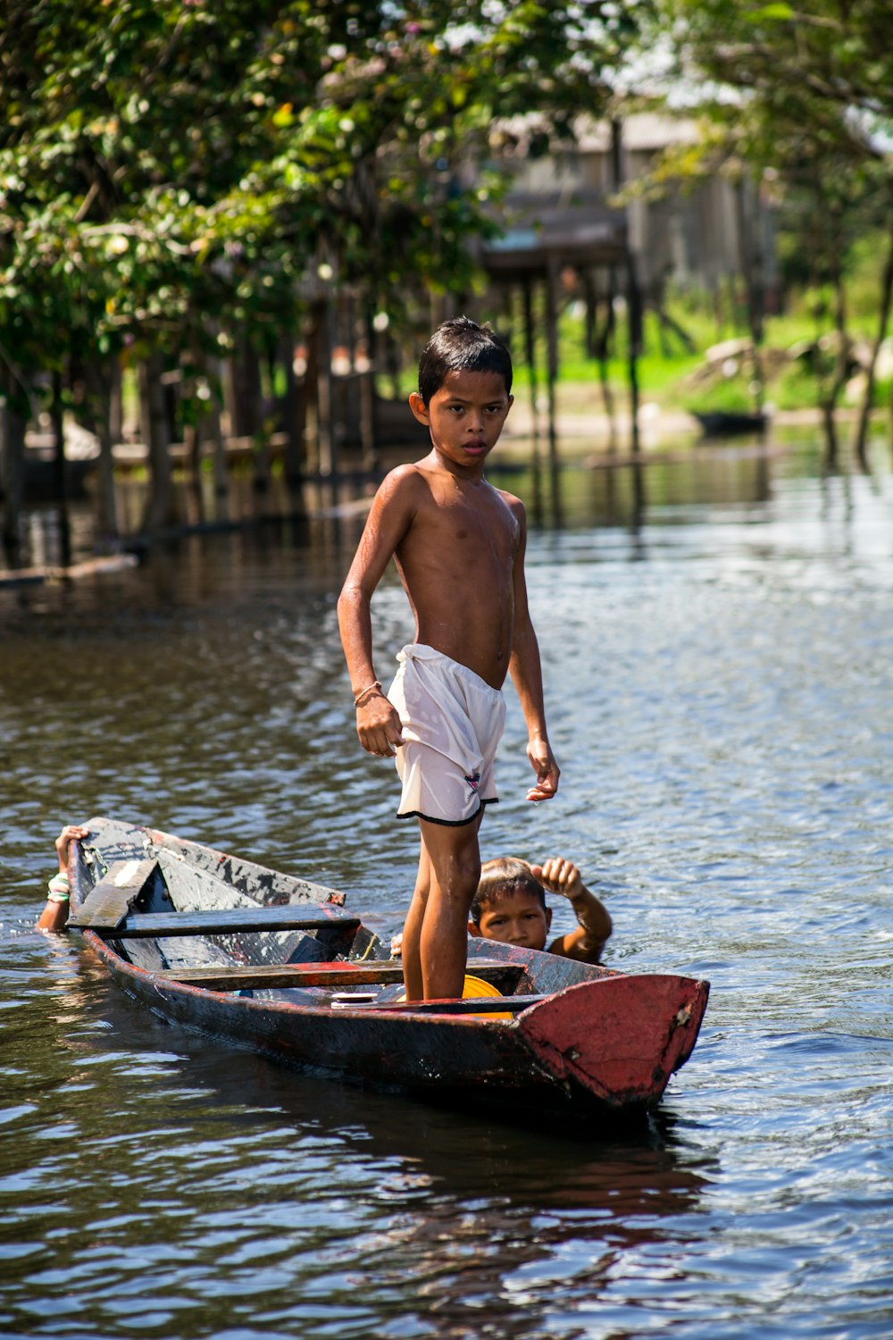 selective focus photography of boy standing on boat