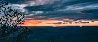 Sunset over Kanab's red rock cliffs with a cozy cabin in the foreground.