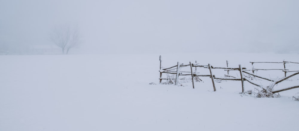 a snow covered field with a wooden fence