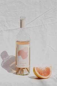 A chilled bottle of rosé wine resting on a rustic wooden table with soft natural light highlighting its pink hue.