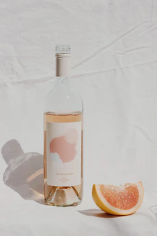 Elegant bottle of rosé wine with honeycomb pattern label on a wooden table.