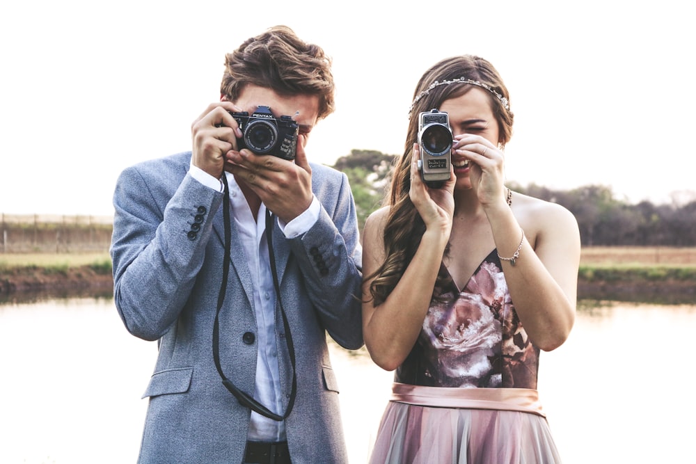 woman and man holding cameras