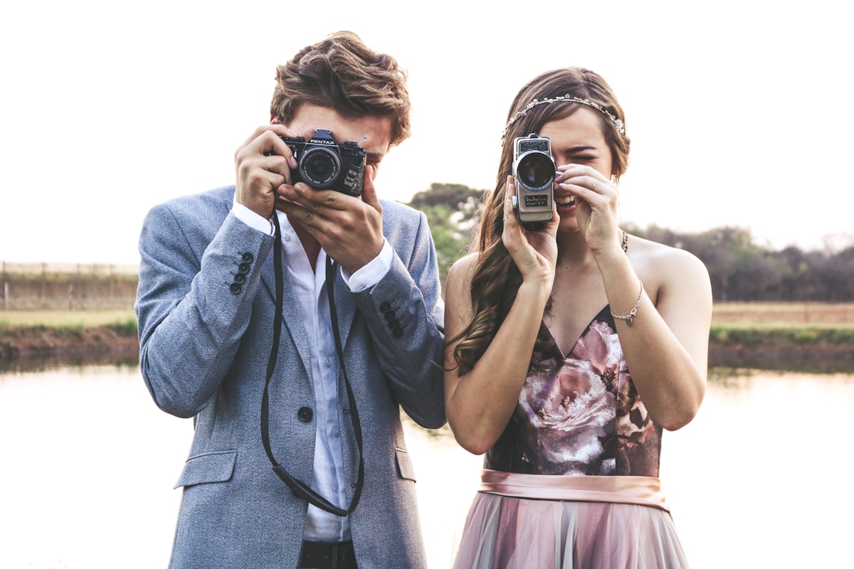 Two photographers holding cameras at an event