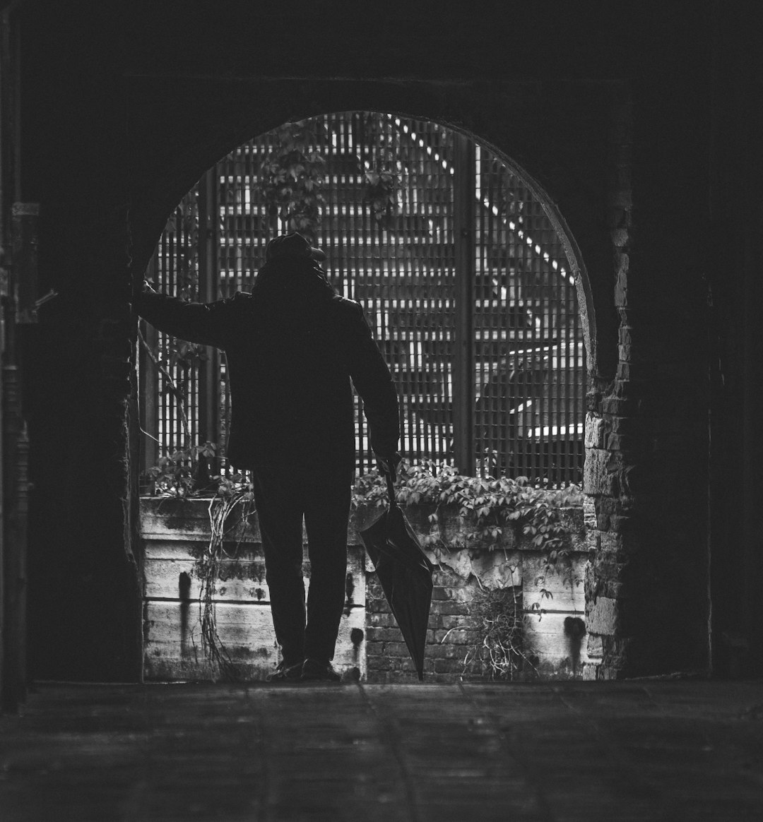 person leaning in a wall grey-scale photography