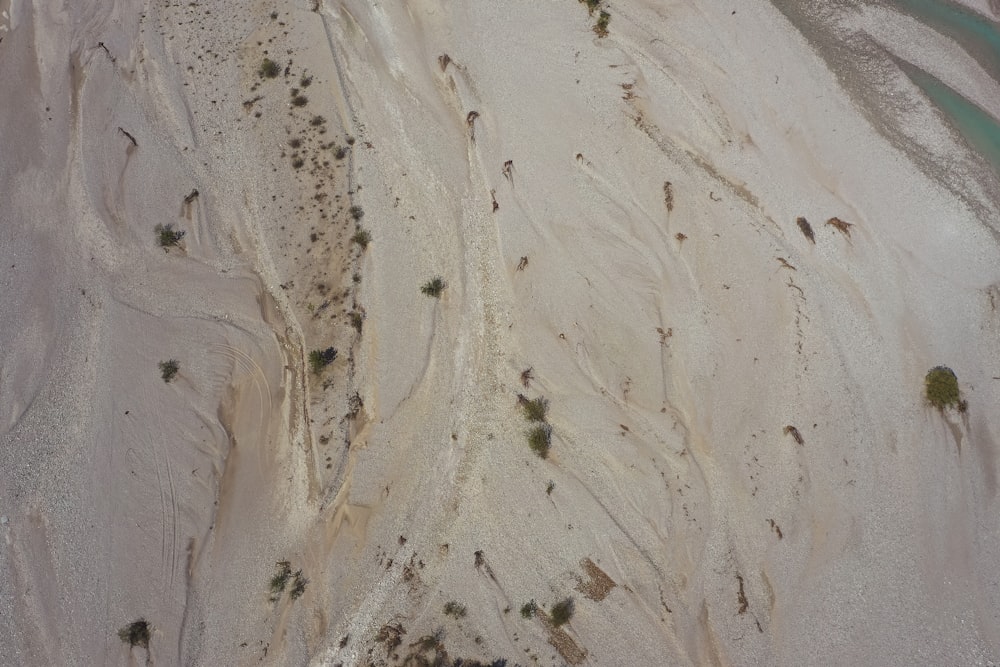 an aerial view of a sandy beach and water