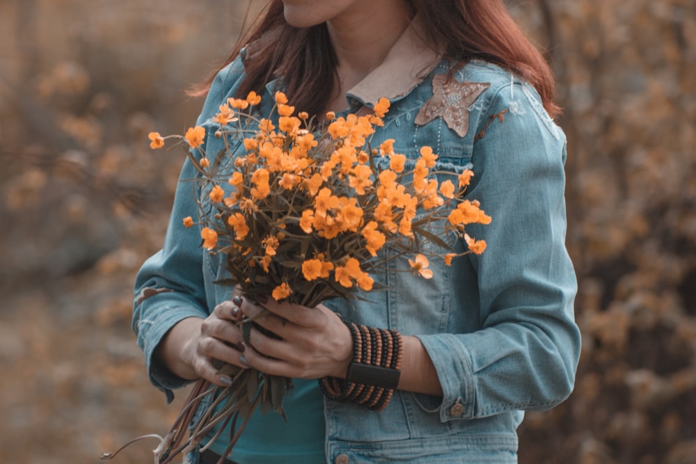 woman holding bouquet of yellow flowers