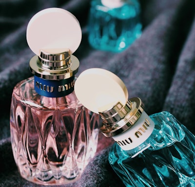 three green and pink bottles on black textile