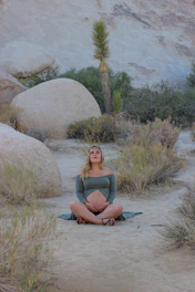 woman seated near rock