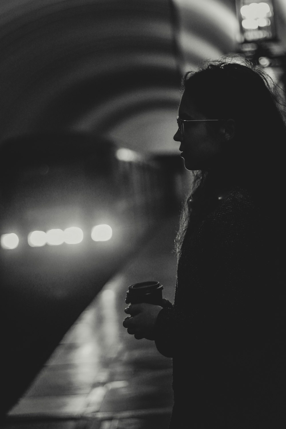 grayscale photography of woman on train station