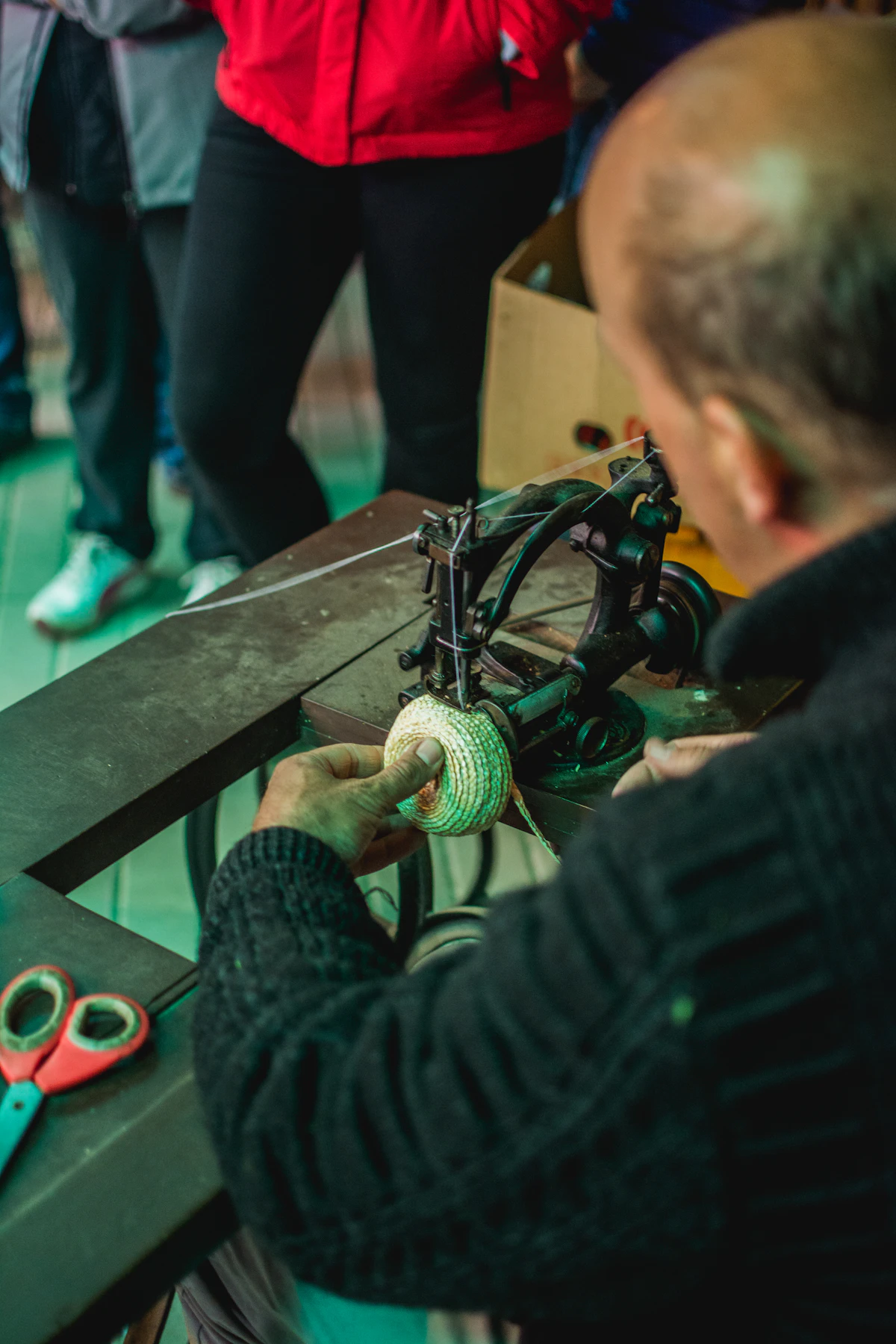 Artisan en train de coudre une pièce en cuir dans son atelier