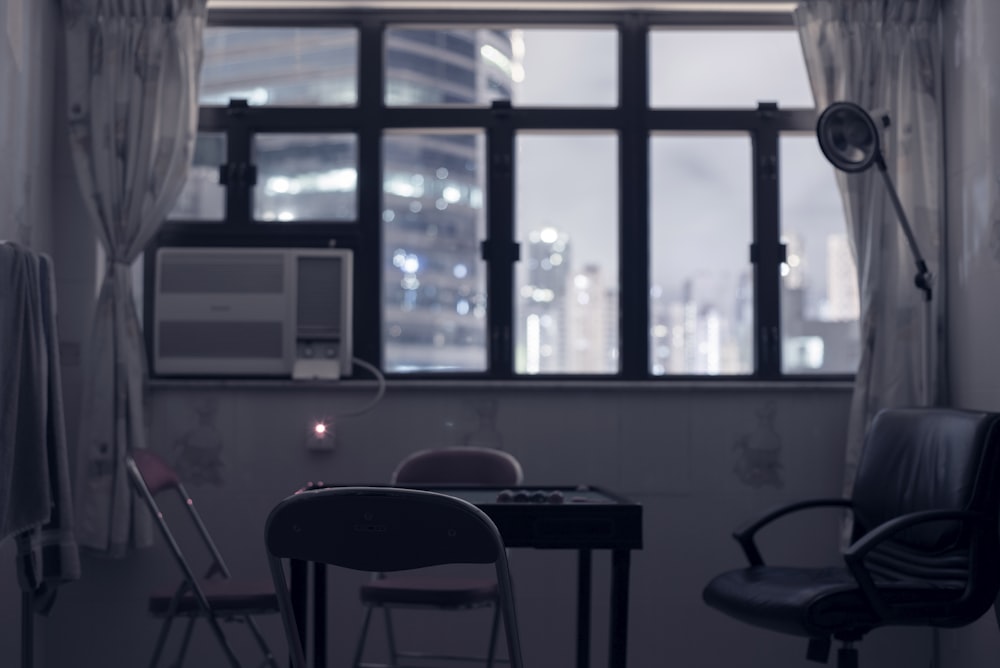 window-type AC unit near empty chairs and table