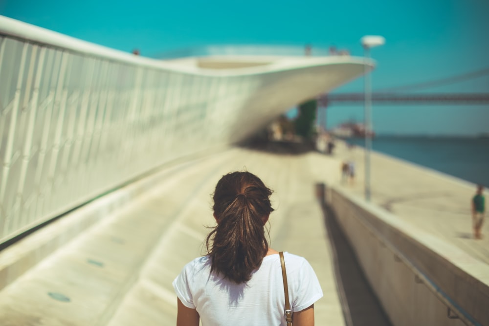 woman wearing white top walking under blue sky during daytime