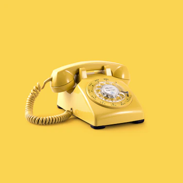 Yellow telephone representing a free discovery call.
