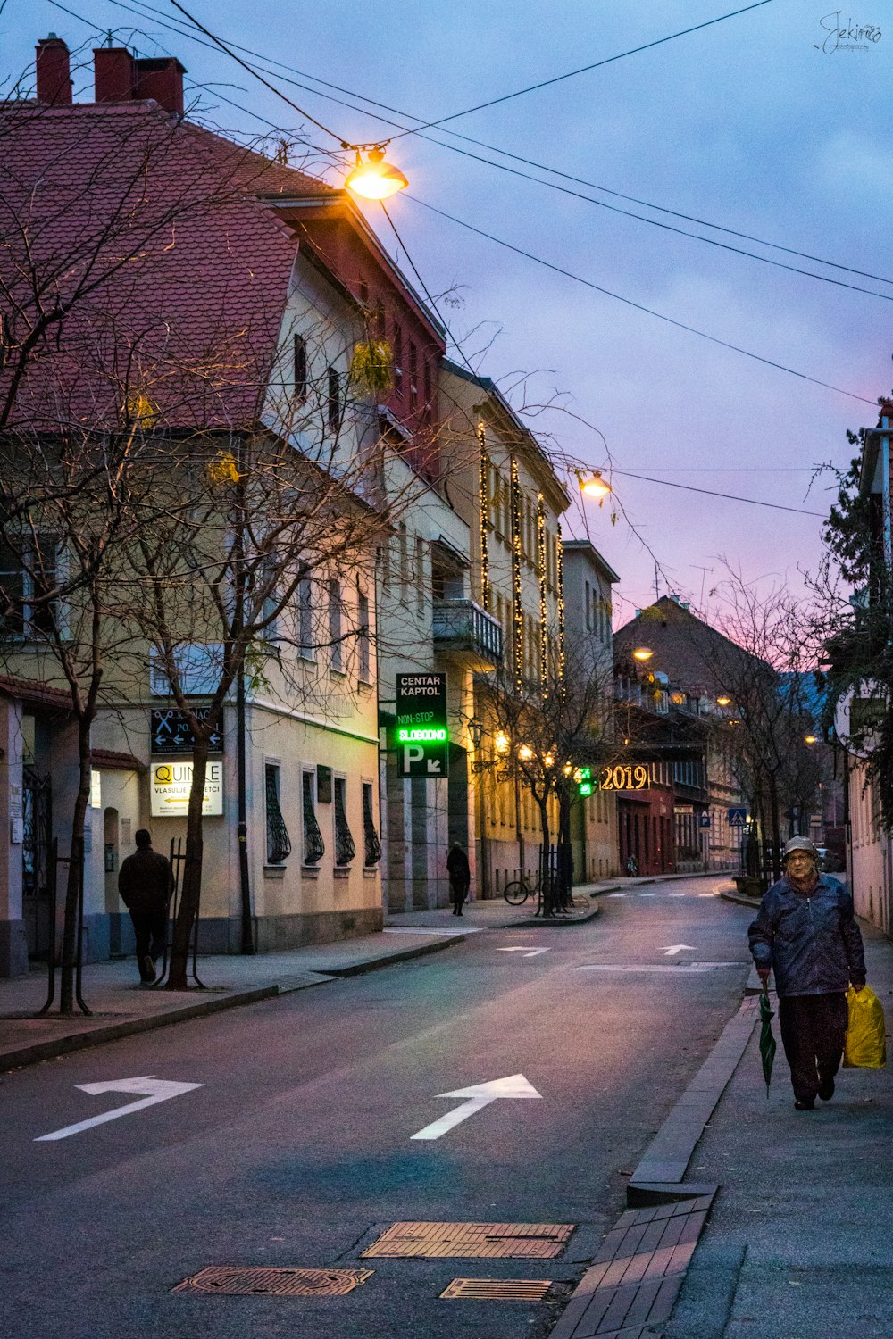 people walking on sidewalk near building during night time