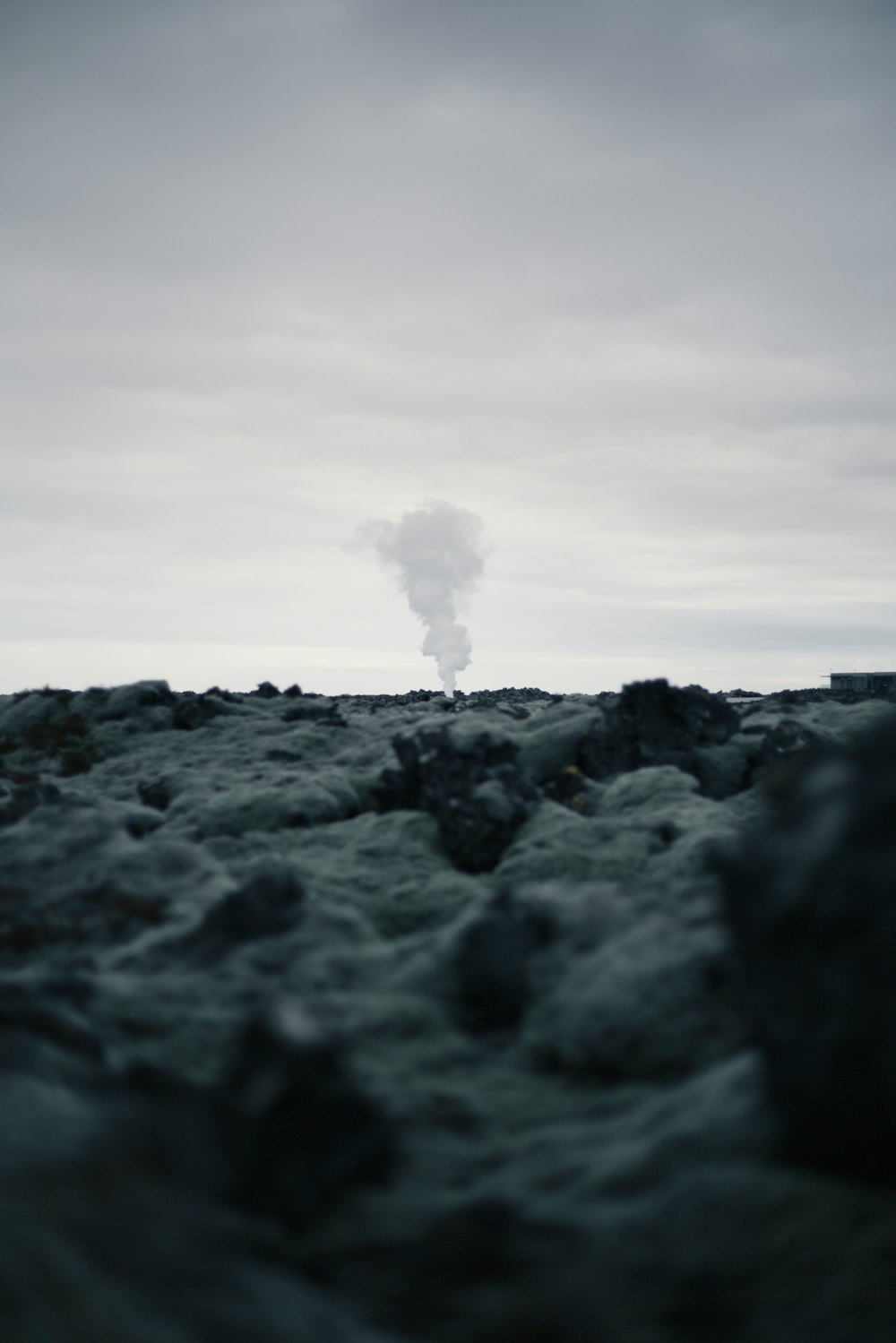 white smoke coming out from black rock formation