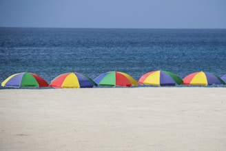 five parasols at the shore during day