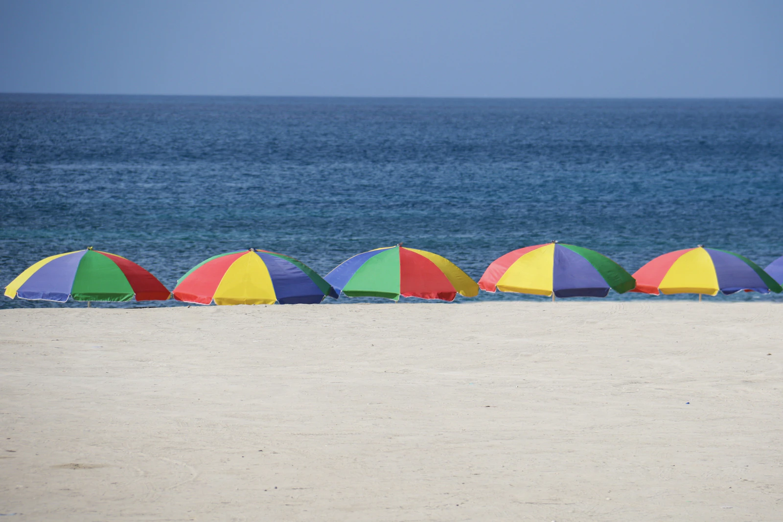Five parasols at the shore during day