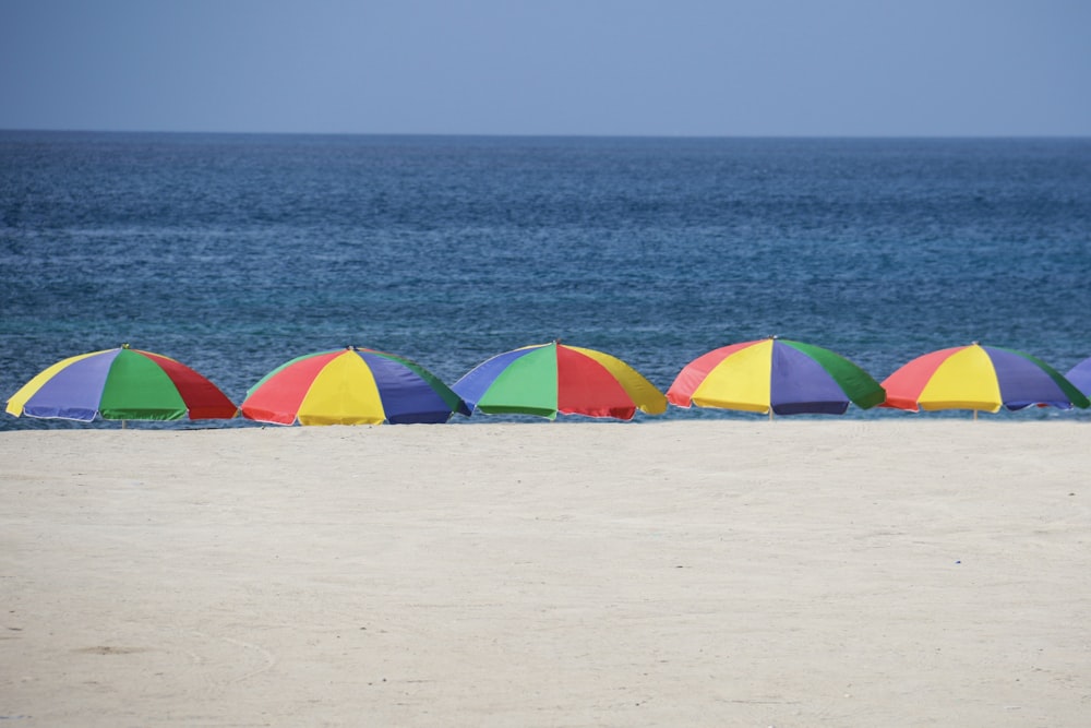 Cinq parasols sur le rivage pendant la journée
