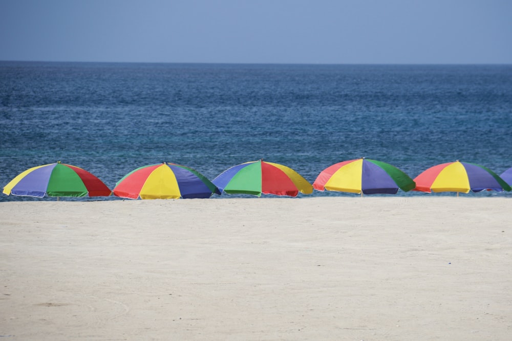 five parasols at the shore during day