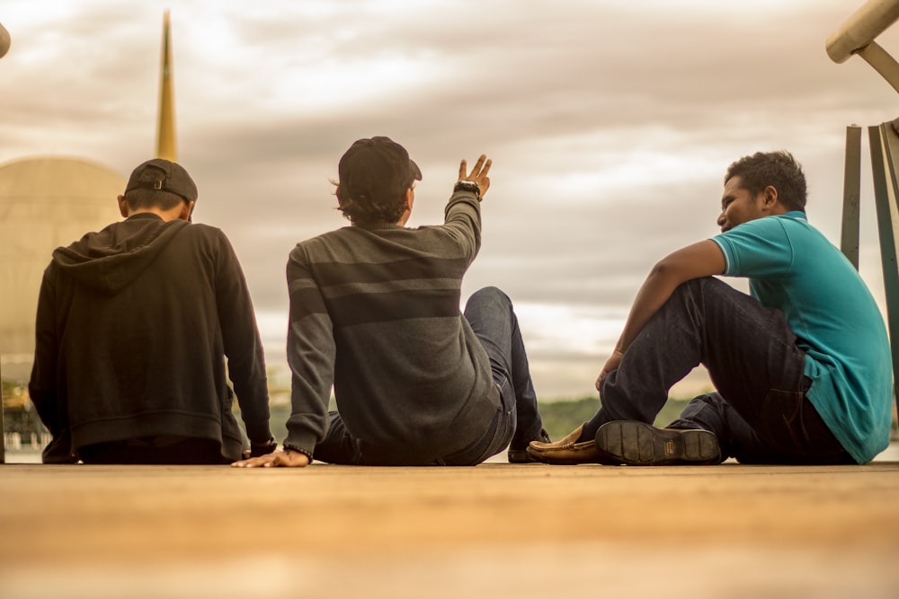 three men sitting on ground