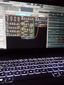 A computer screen displays a digital audio workstation with various audio controls and modules visible. The screen is filled with plugins and mixer settings for music production. Below the screen, a laptop keyboard is visible, illuminated by a backlight.
