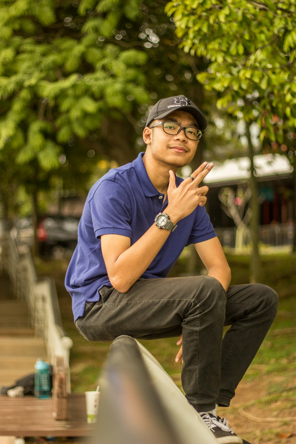 man sitting on gray bar smiling near green field